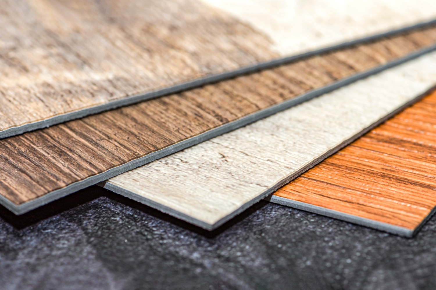 Samples of vinyl floor tiles with different wooden textures and colors