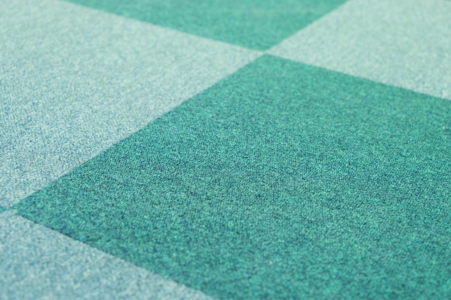 A closeup image of teal checkered carpet tiles